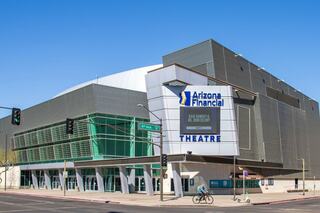 A modern theater with distinctive architecture, featuring glass and metal elements, prominently displaying "Arizona Financial Theatre" signage.