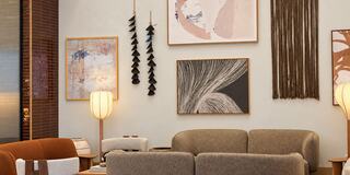 A cozy living room features modern art, soft furnishings, warm lighting, and a stylish blend of textures and colors for a welcoming atmosphere.