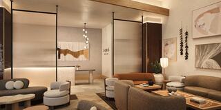 A modern, stylish lounge features comfortable seating, warm tones, and artistic decor, creating a cozy, inviting atmosphere.