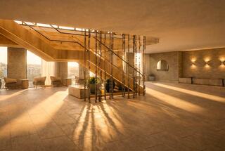 A charming winery nestled among lush vineyards, with a clear blue sky above and greenery enhancing the serene landscape.