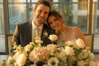 A luxurious banquet hall with elegant tables, floral arrangements, and extravagant chandeliers, offering stunning city views.