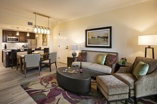 A cozy living space features stylish furniture, a dining area, a modern kitchen, and elegant decor, creating a warm atmosphere for relaxation.