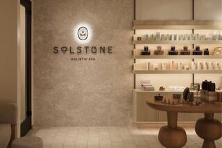 A serene spa interior features a calming color palette, natural materials, and neatly arranged wellness products on display.